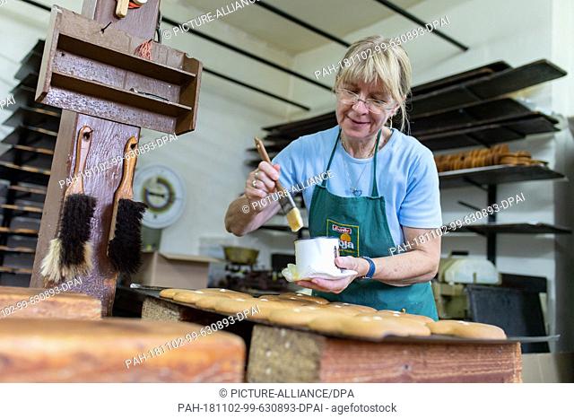 09 October 2018, Hessen, Reichelsheim: Employee Hedwig Gräber spreads gingerbread with potato starch in the workrooms of the Baumann gingerbread bakery