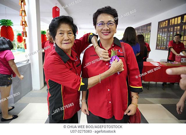 Pinning flower for VIP during Sarawak Chai's Clan Association Chinese New Year dinner party in Kuching, Malaysia