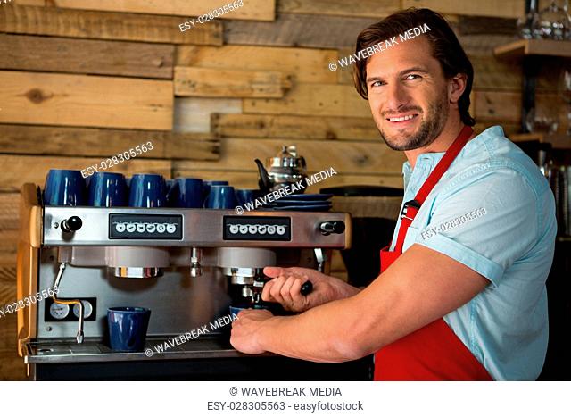 Barista preparing coffee with machine in coffee shop