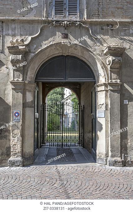 detail of crumbling Baroque portal of historical building in town center, shot in bright summer light at Crema, Cremona, Lombardy, Italy