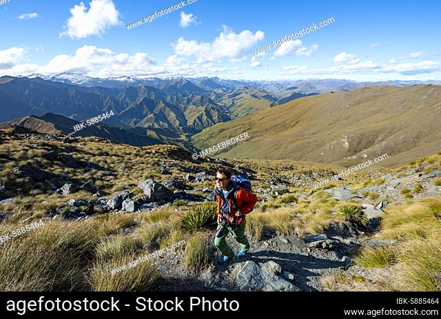 Hiker on the hiking trail to Ben Lomond, views of mountain ranges, Southern Alps, Otago, South Island, New Zealand, Oceania