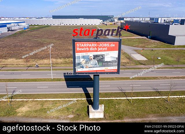29 March 2021, Saxony-Anhalt, Halle: An oversized sign advertises the Star Park on the A14 motorway. The 230-hectare industrial estate was originally created in...