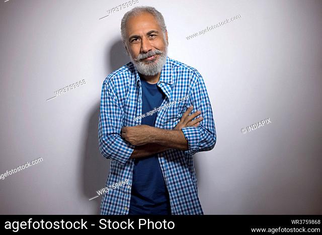 A STYLISH OLD MAN POSING IN FRONT OF CAMERA