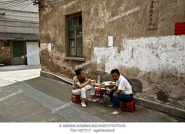 Couple eating at a table in the street. Guilin, China