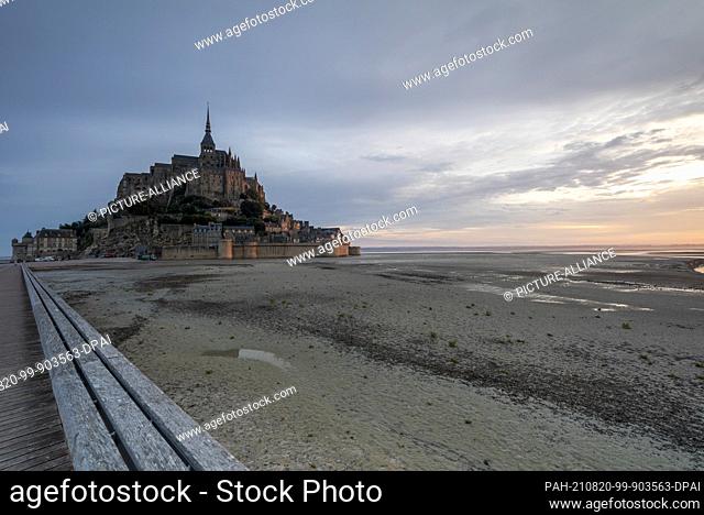 12 August 2021, France, Le Mont Saint Michel: Before sunrise, the tide is out at Mont Saint Michel. The rocky monastery island in the Normandy tidal flats is...