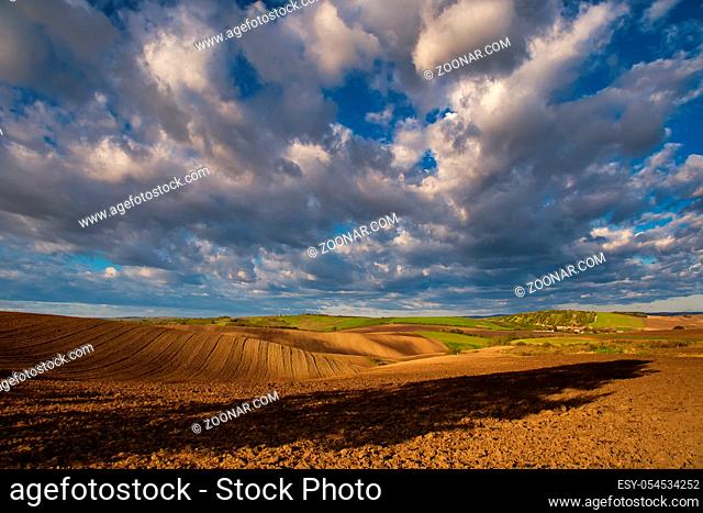 Rolling fields of South Moravia in the autumn morning with a sky full of fast-moving clouds after a storm, Moravian Tuscany, Czechia