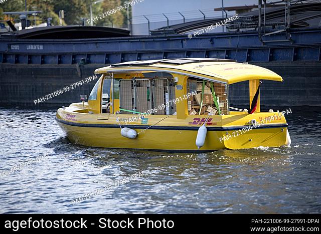 06 October 2022, Berlin: A Deutsche Post DHL solar ship sails into Berlin's Westhafen. DHL launches parcel transport by water with an electrically powered solar...