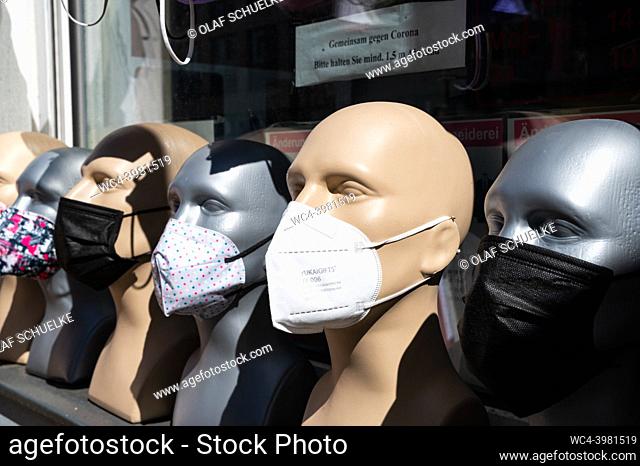 Berlin, Germany, Europe - Display and selection of various protective face masks against the coronavirus (Covid-19) on mannequin heads in front of a retail...