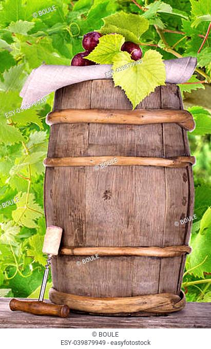Ripe grapes on a wooden vintage barrel with corkscrew