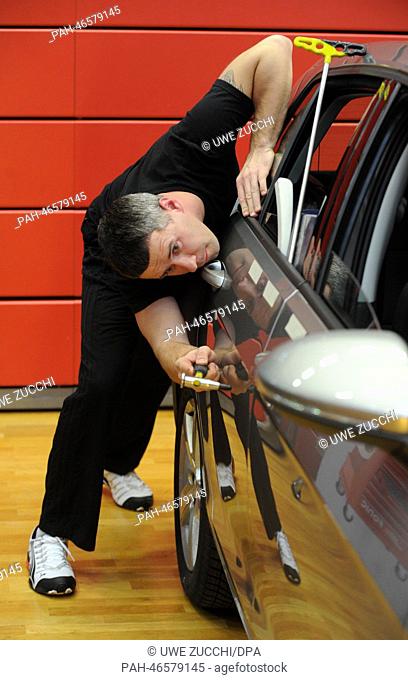 Participant Vadim Varblane removes a dent during the dent removing championship in Rotenburg a.d.Fulda, Germany, 22 February 2014