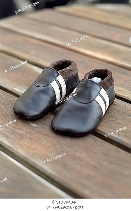 Leathery Children's Shoes on a wooden Underlay - Clothing - Childhood