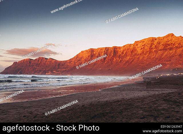 Landscape of beach and red mountains inbackground. Seascape with peaceful feeling and moment. Scenic place with ocean and sand