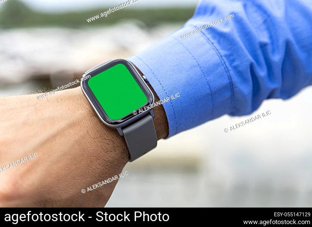 Smart watch on the man's hand with chroma key display for copy space, add text or logo