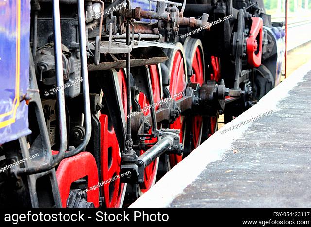 Powerful wheels of old locomotive stands on the railroad tracks on the day of the railwayman