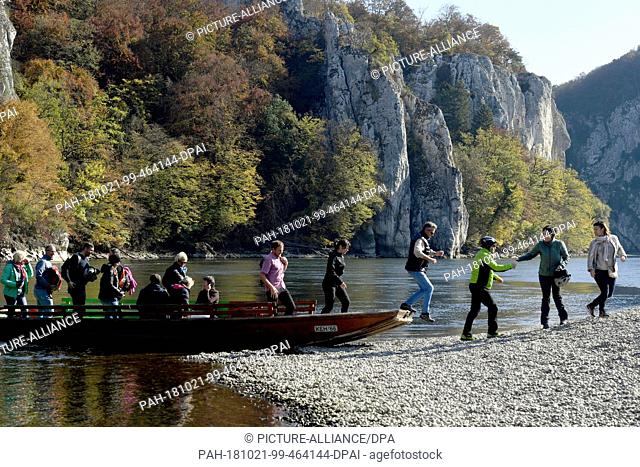 21 October 2018, Bavaria, Weltenberg: In sunny autumn weather, excursionists get off a passenger ferry at the Danube breakthrough near Weltenburg Monastery