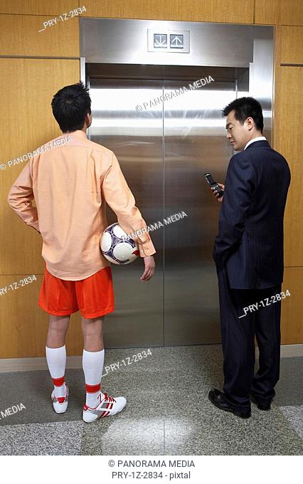 Two young men standing in front of lift