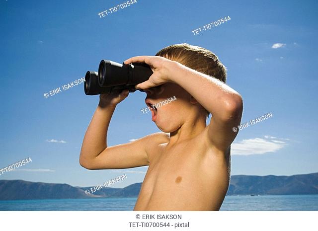 Boy looking through binoculars, Utah, United States