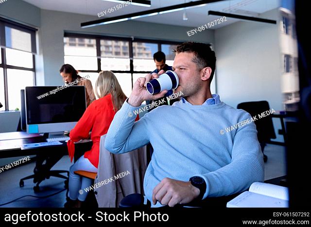 Caucasian man drinking coffee in office