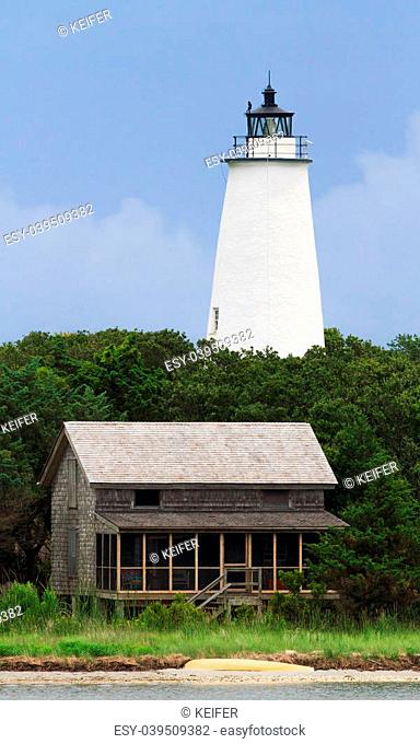 The Lighthouse and a beach house with shake siding are viewed from the water off Ocracoke Island, part of North Carolina's Outer Banks