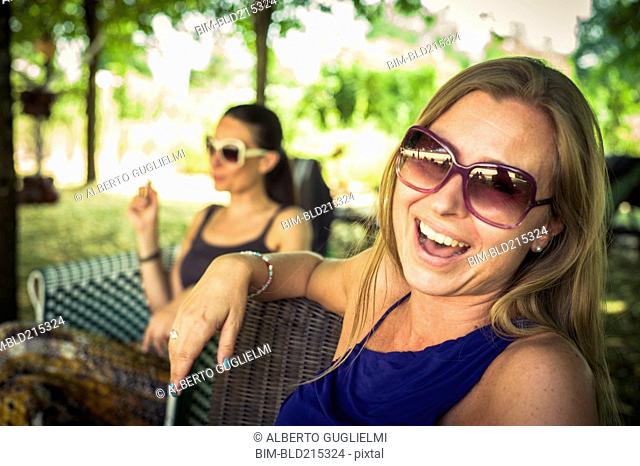 Caucasian women sitting in chairs in backyard