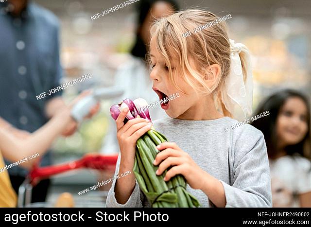 Girl holding bunch of red onions