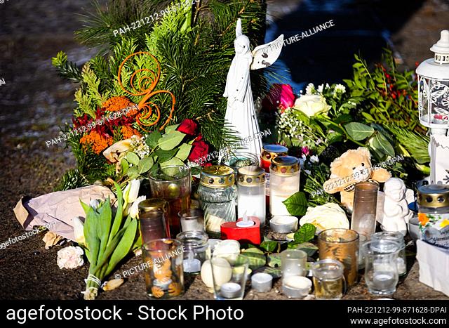12 December 2022, Berlin: Flowers and candles lie at the Stadtbad Lankwitz bus stop after an accident involving a double-decker bus in which a teenager died on...