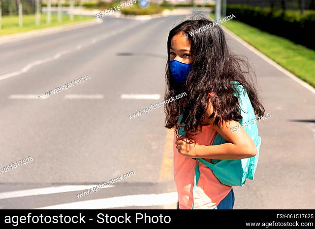 Girl wearing face mask standing on the road