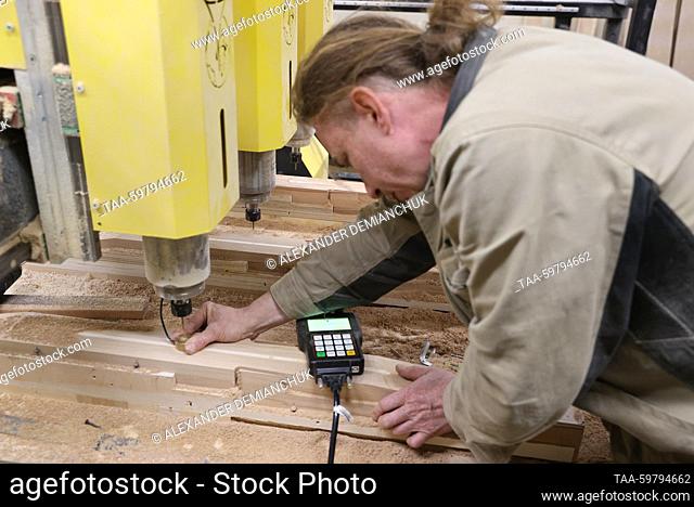 RUSSIA, ST PETERSBURG - JUNE 13, 2023: A woodworker in the mechanical working shop at the Resonance Harps musical instrument factory