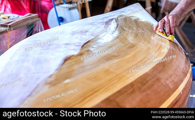 19 May 2022, Mecklenburg-Western Pomerania, Peenemünde: Time and again, Ulrich Stenberger from Raubling near Rosenheim has to wipe sanding dust off his canoe...