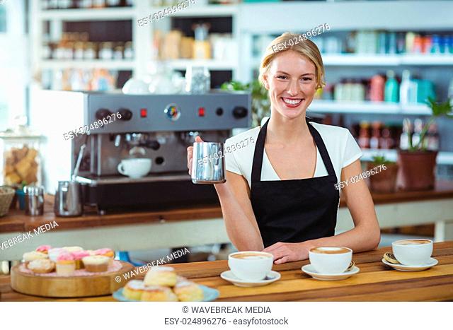 Portrait of waitress making cup of coffee at counter