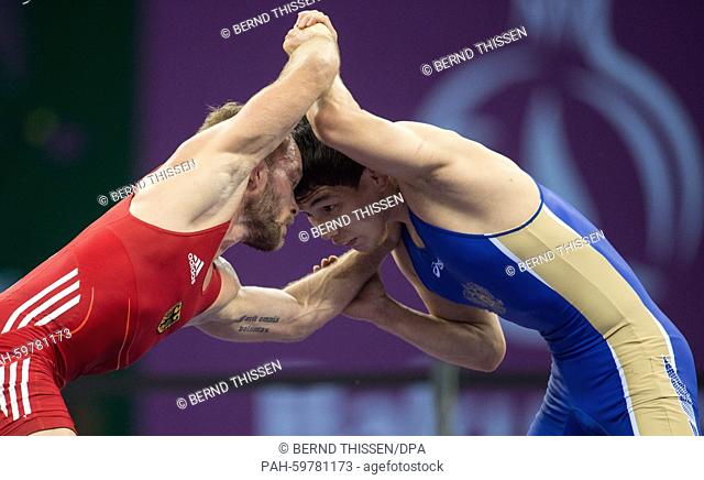 Germany's Marcel Ewald (red) competes with Viktor Lebedev (blue) of Russia in the wrestling Men's 57kg Freestyle Finale at the Baku 2015 European Games in the...