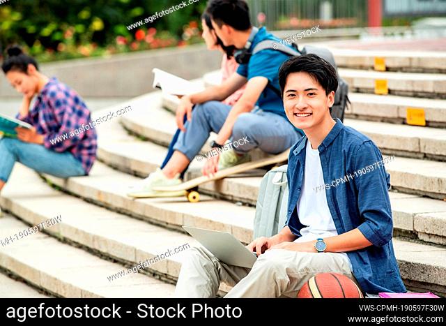 Happy college students sat on the steps of learning