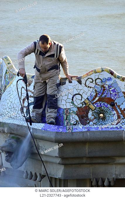Man cleaning mosaics. Guell Park Parc Guell by Antoni Gaudi, Barcelona, Catalonia, Spain