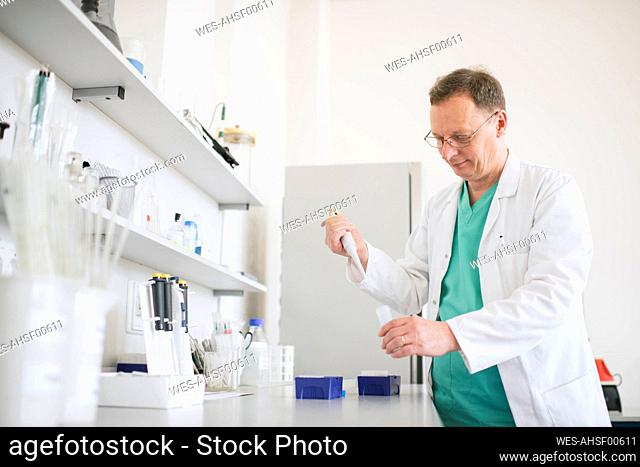 Researcher in white coat working in lab
