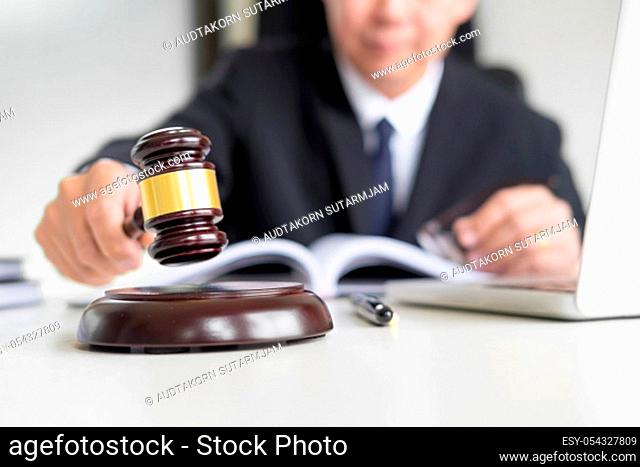 Male Judge lawyer In A Courtroom Striking The Gavel on sounding block