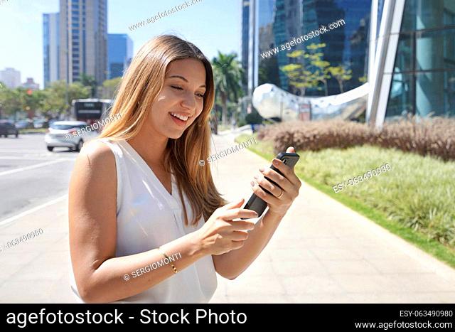 Business woman checking telepone in financial district of Sao Paulo, Brazil