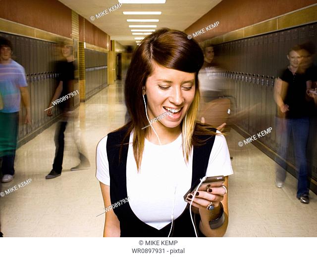 High School girl at school listening to MP3 player