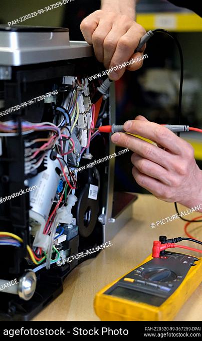 20 May 2022, Saxony, Leipzig: Electronic measured variables are determined on a fully automatic coffee machine in a repair workshop