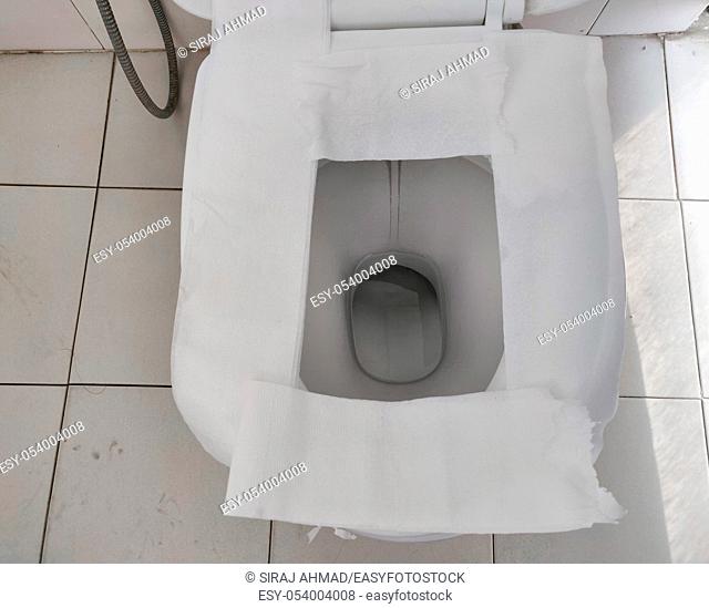Toilet paper put on Open Toilet seat. Cover The Toilet Seat With Tissue Paper. Public toilet