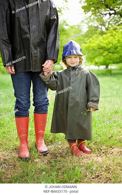 Mother and daughter walking in the rain in a park, Sweden