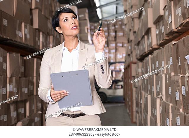 Warehouse manager checking her inventory in a large warehouse