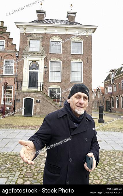 Friesian senior man in front of city hall of Workum, Friesland, Netherlands
