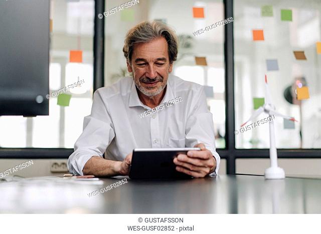 Senior businessman using tablet in conference room in office