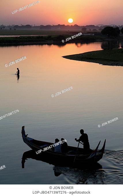 Myanmar, Mandalay, Lake Taungthaman. Fishermen and tourist boats on Taungthaman Lake in Myanmar at sunset viewed from U Bein Teak Bridge