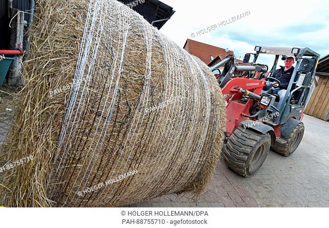 Farmer Andreas Strahlmann drives a tractor at his farm in Wettmar, Germany, 28 February 2017. 60 horses live in the horse boxes he rents out to private owners