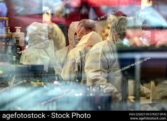 07 June 2022, Hessen, Schwalmstadt: Forensic experts stand in a supermarket. In the case of the fatal shooting in a supermarket in Schwalmstadt