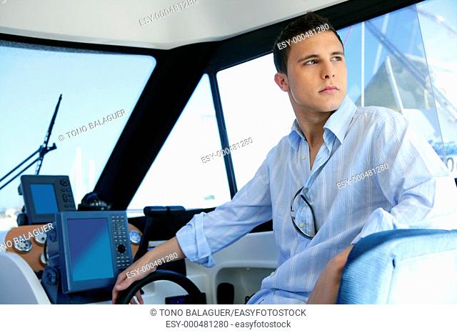 Young handsome man on a yacht boat interior in summer