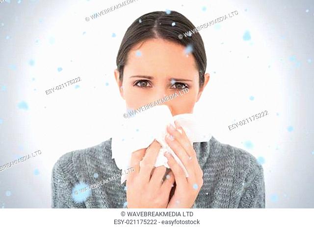 Composite image of portrait of a casual young woman suffering from cold