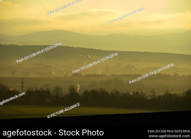 08 December 2020, Hessen, Fulda: View from the Fulda district Dietershan at sunrise to the heights of the ""Naturpark Hessische Rhön""