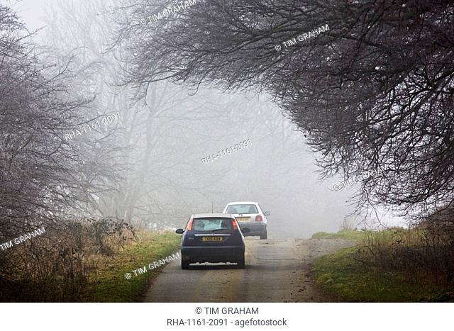 Cars drive along foggy road, Oxfordshire, United Kingdom